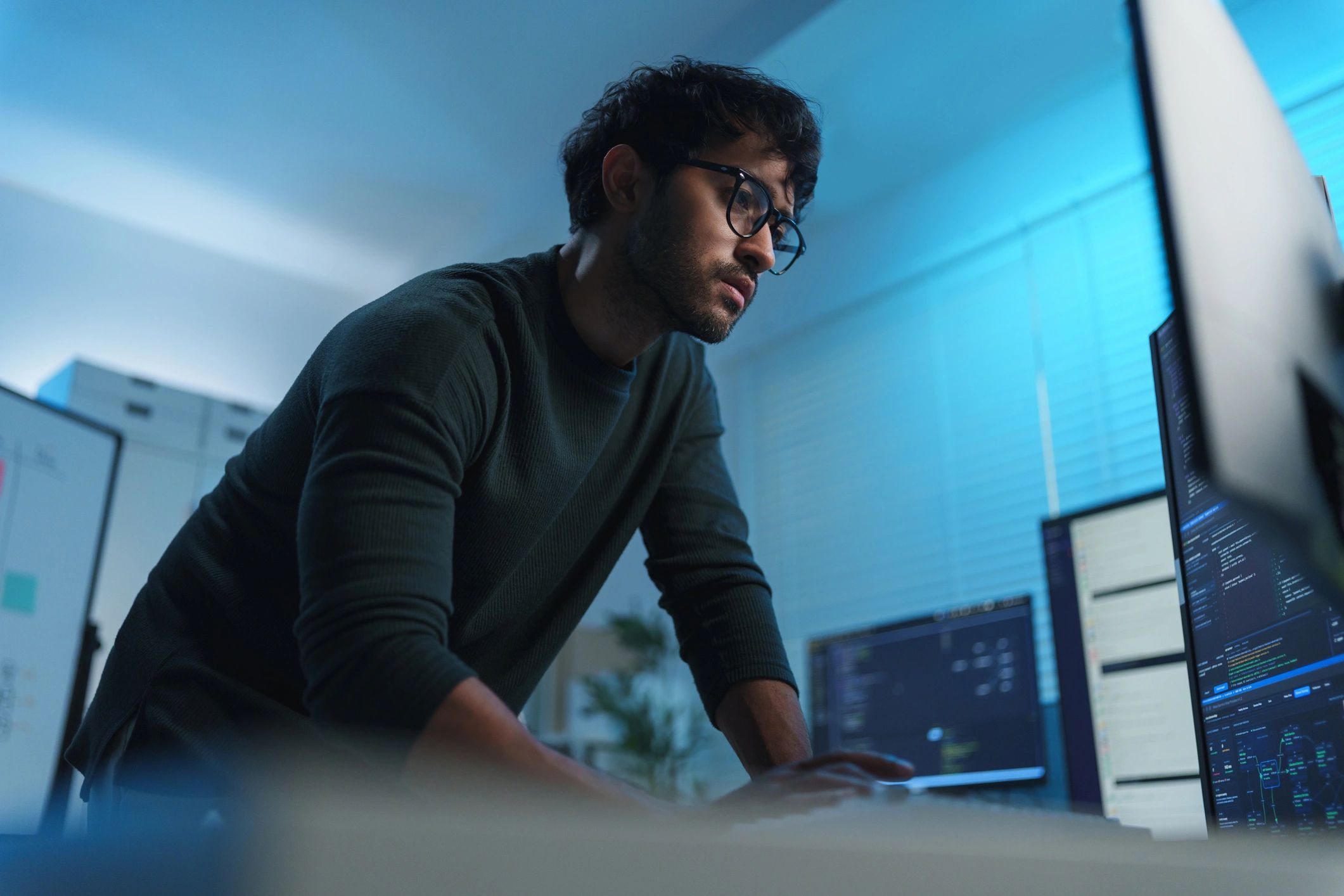 Software developer working across multiple monitors